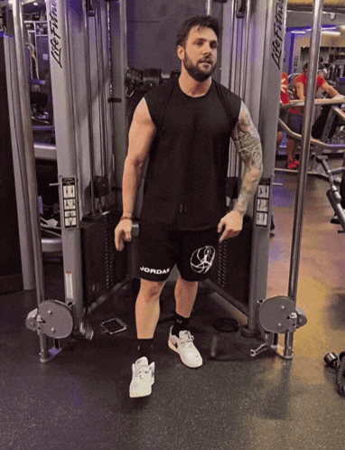 a man is standing in front of a machine that says life fitness
