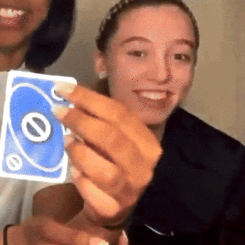 a woman is holding a blue uno card in her hands