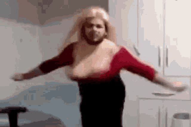 a woman with large breasts is dancing in a room .