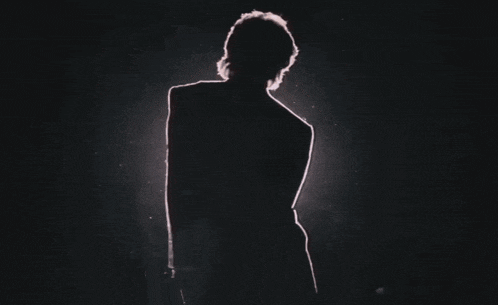 a silhouette of a person in a dark room with a red light behind them