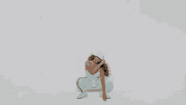 a woman in a blue jumpsuit and hat is dancing against a white background .