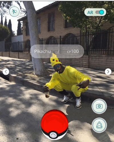 a man in a pikachu costume is squatting on the sidewalk