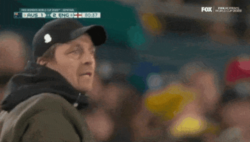 a man in a green jacket is watching a soccer game between australia and england