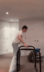 a man is using a walker in a bedroom