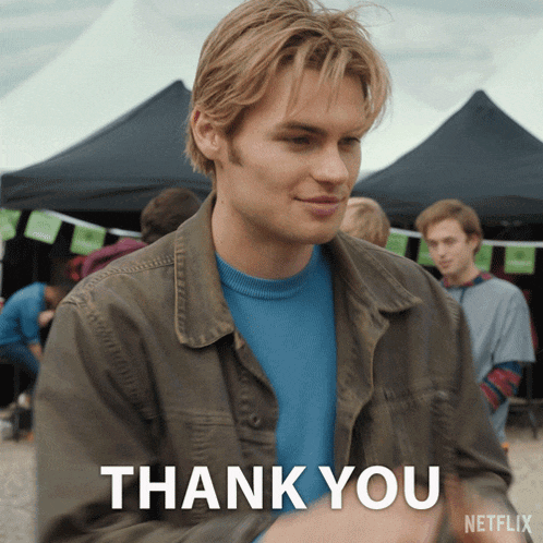 a man in a brown jacket and blue shirt says thank you