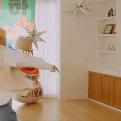 a birthday balloon is in a living room with a person