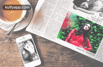 a newspaper with a picture of a woman is on a table next to a cup of coffee
