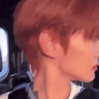 a close up of a person 's neck and ear while sitting in a car .