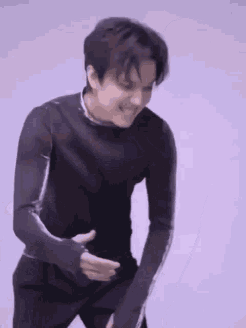 a man in a black shirt is dancing and making a funny face