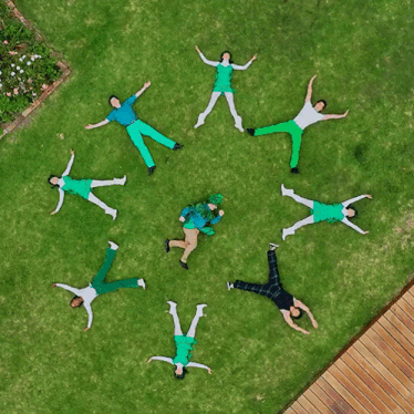 a group of people laying on the grass in a circle