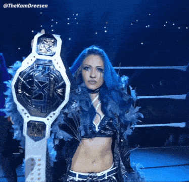 a woman with blue hair is holding a championship belt with the hashtag @thekamdreesen