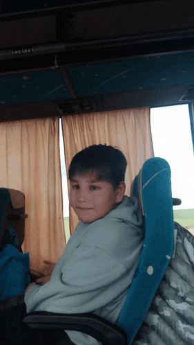 a young boy is sitting in a blue chair with the number 1 on the top
