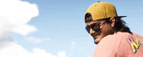 a man wearing sunglasses and a yellow hat with the letter a on his shirt