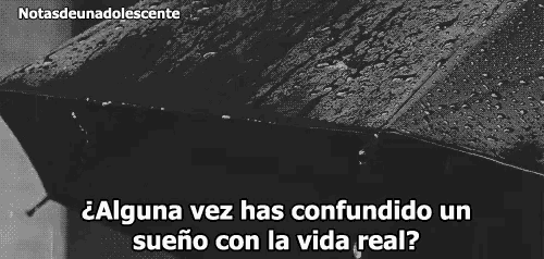 a black and white photo of an umbrella in the rain with a quote in spanish