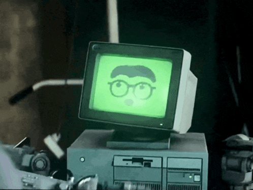 a computer monitor with a green screen and a picture of a man wearing glasses
