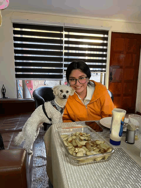 a woman sits at a table with a dog and a container of mayonnaise