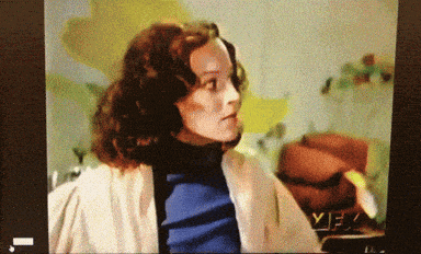 a woman in a blue turtleneck sweater is on a tv screen that says yfx