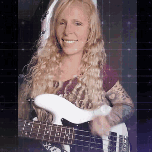 a woman with blonde hair is holding a white guitar and smiling