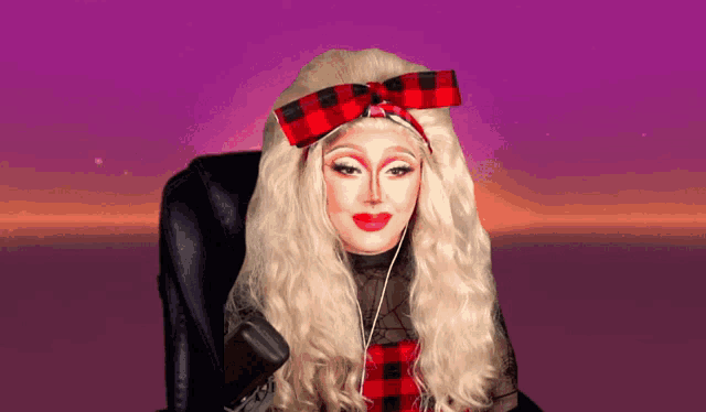 a drag queen wearing headphones and a plaid headband