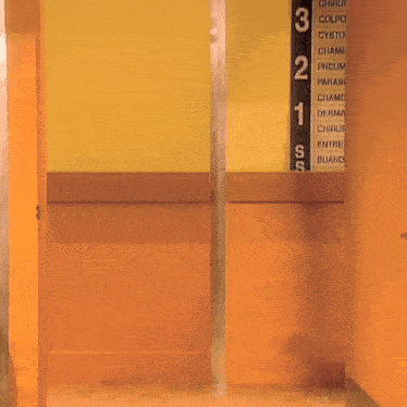 a nurse is riding a bicycle in front of a wall with numbers 3 and 2 on it