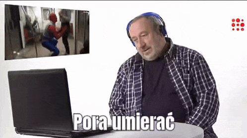 a man wearing headphones is sitting in front of a laptop with the words " pora umierac " written on it