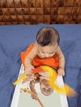 a baby is playing with a toy and looking at its reflection in a mirror