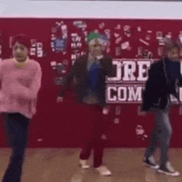 a group of people are dancing in front of a sign that says jre com .