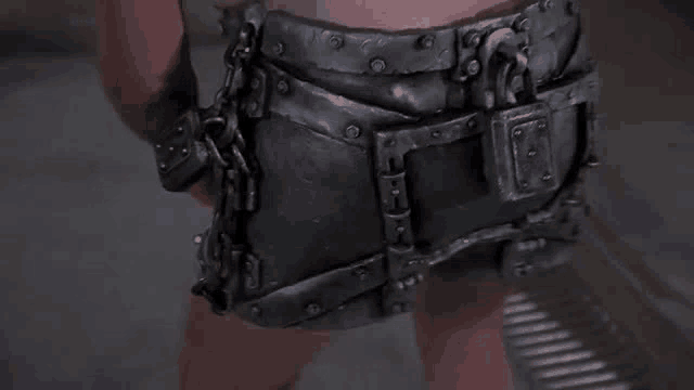 a close up of a person wearing a chain belt .