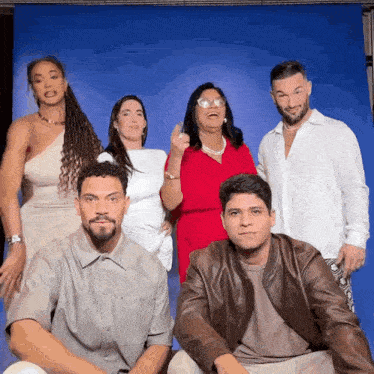 a group of people are posing for a picture in front of a blue backdrop