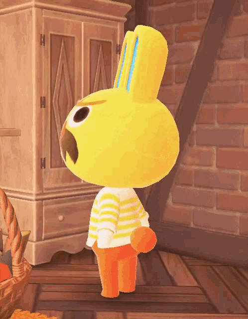 a yellow and orange bunny with a striped shirt is standing in front of a brick wall