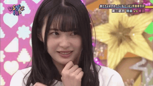 a girl with long hair and bangs is smiling in front of a sign that says " vs "