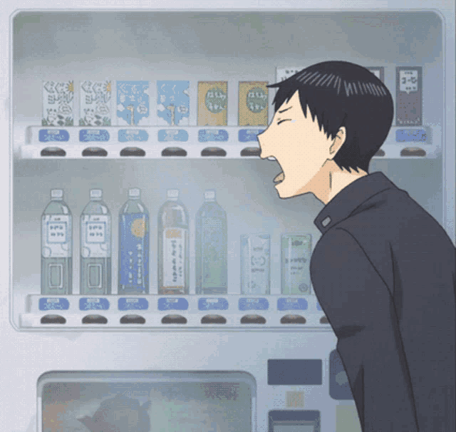 a man is standing in front of a vending machine with bottles and boxes of drinks on it