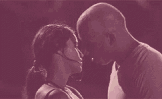 a man and a woman are kissing in front of a red background