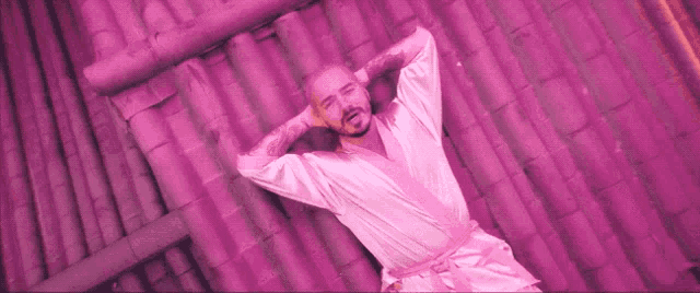 a man in a pink robe is laying on a roof