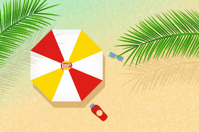 a red white and yellow lays umbrella sits on a sandy beach