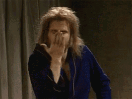 a man with long hair and a beard is making a wink sign with his finger