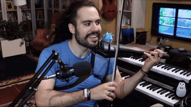 a man playing a violin in front of a microphone and keyboard