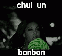 a woman is eating a green lollipop in a car with a caption that says ` ` chui un bonbon ` ` .