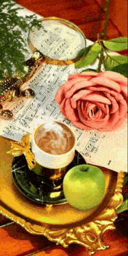 a cup of coffee sits on a saucer next to a green apple and a pink rose