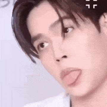 a close up of a young man sticking out his tongue .