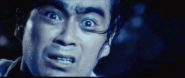 a close up of a man 's face with a shocked look on his face