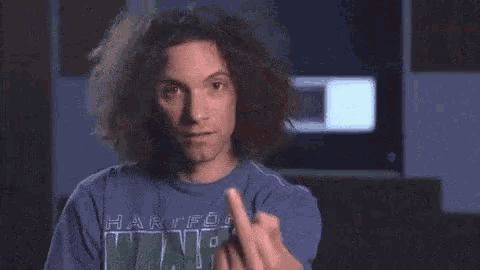 a man with curly hair is wearing a blue shirt that says hawks on it