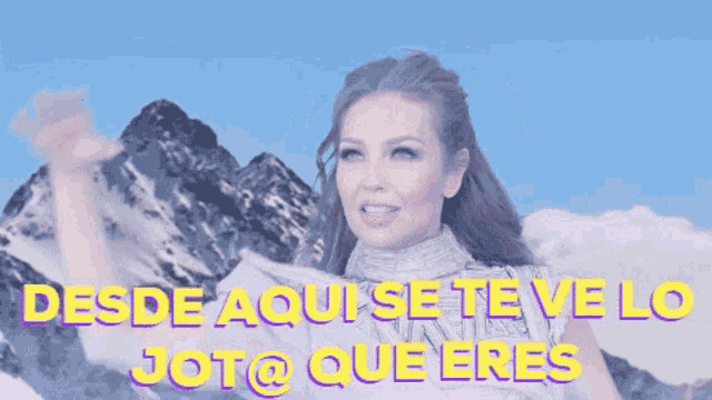 a woman waves her hand in front of a mountain with the words desde aqui se te ve lo jot @ que eres