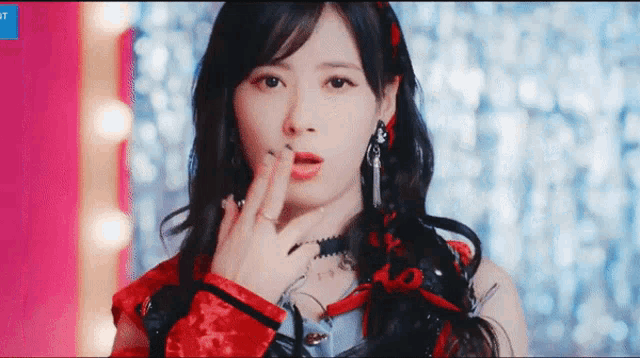 a woman in a red dress is making a gesture with her hand