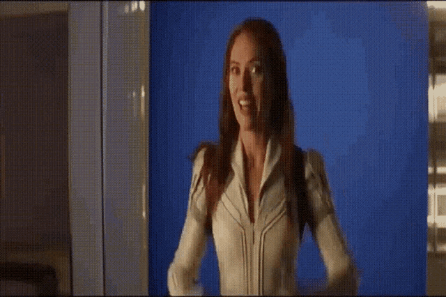 a woman is giving a thumbs up in front of a blue background
