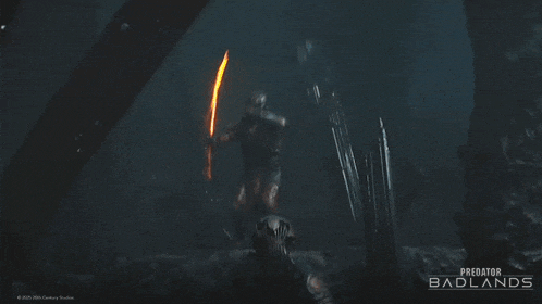 a poster for predator badlands shows a person laying on the ground in a cave