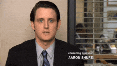 a man in a suit and tie has the name aaron shure below him