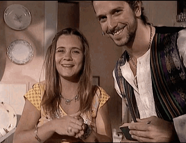 a man and a woman are standing next to each other and smiling for the camera