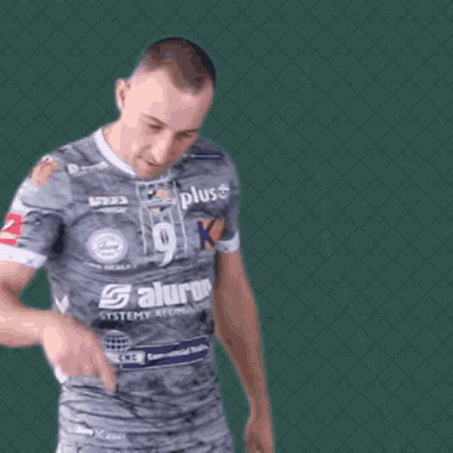 a man wearing a grey shirt that says plus on it