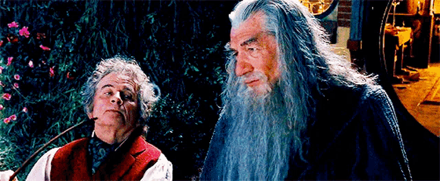 a man with a beard is smoking a pipe next to another man with a long beard .